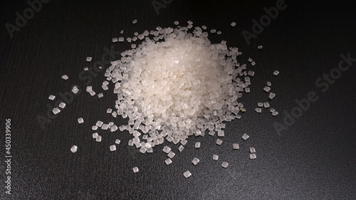 Sugar in glass bowl on wooden background.