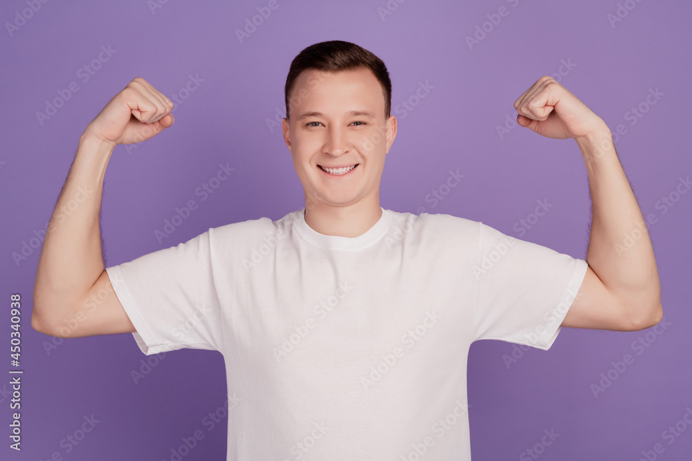 Portrait of cool strong guy raise hands show muscle on violet background Portrait of cool strong guy raise hands show muscle on violet background
