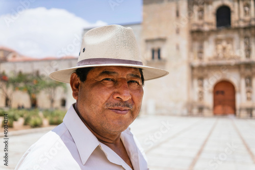 Mexican grandfather smiling at camera. adult latino with hat on a sunny day photo