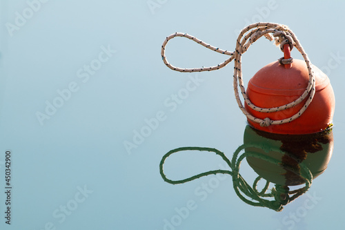Mooring buoy with rope knot on the tranquil water in marina. photo