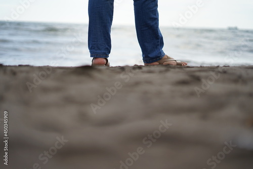 A woman's feet standing on the beach sand © Herwin Bahar