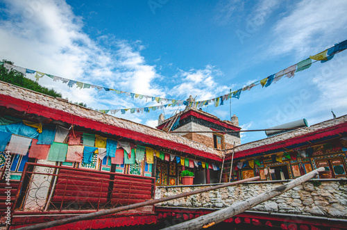 Traditional artistic Tibetan houses hanging with prayer flags for sending blessings