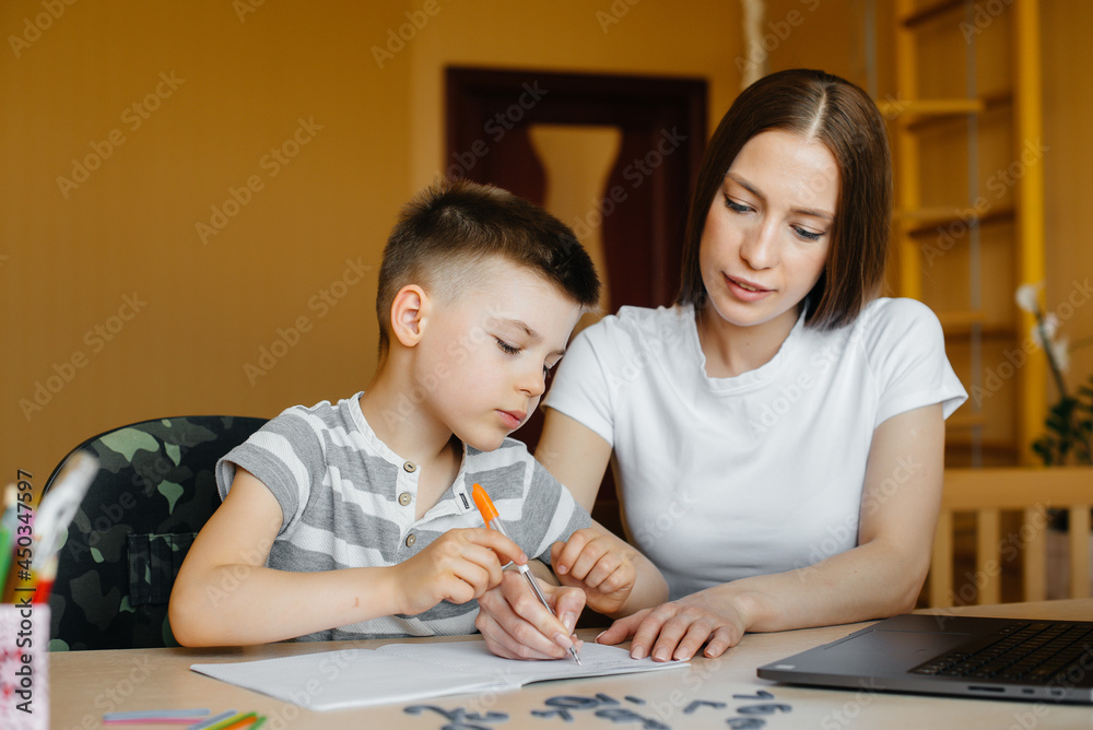 A mother and her child are engaged in distance learning at home in front of the computer. Stay at home, training A mother and her child are engaged in distance learning at home in front of the computer. Stay at home, training