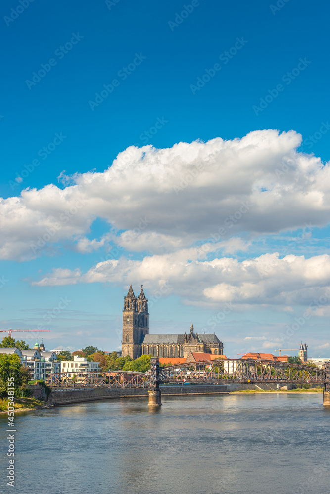 Historical downtown of Magdeburg, old town, Elbe river, old footbridge and Magnificent Cathedral at early Autumn with blue sky and clouds, Magdeburg, Germany.
