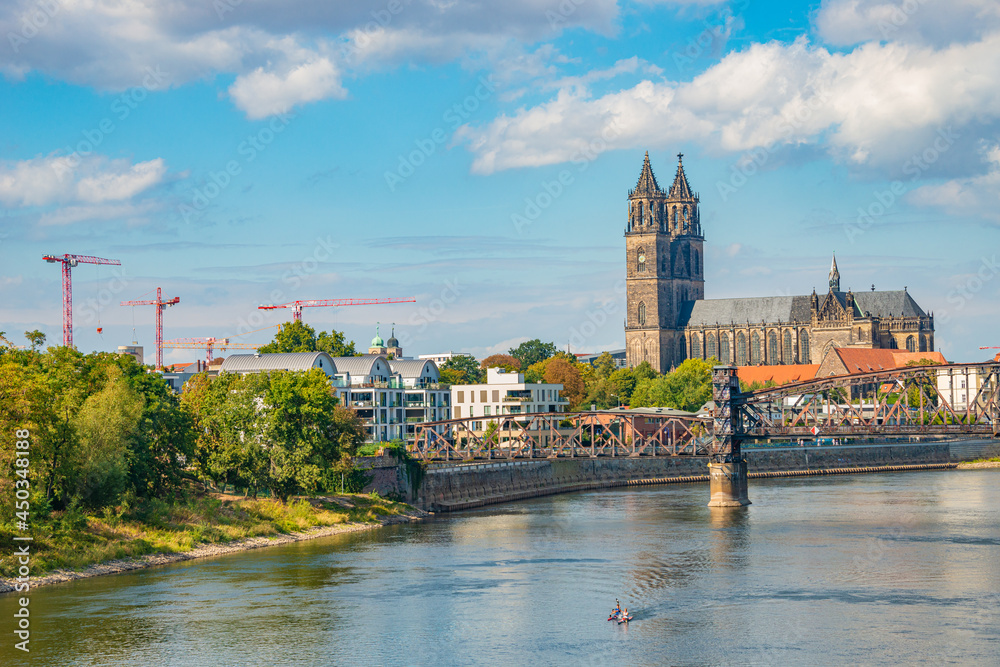 Historical downtown of Magdeburg, old town, Elbe river, old footbridge and Magnificent Cathedral at early Autumn with blue sky and clouds, Magdeburg, Germany.
