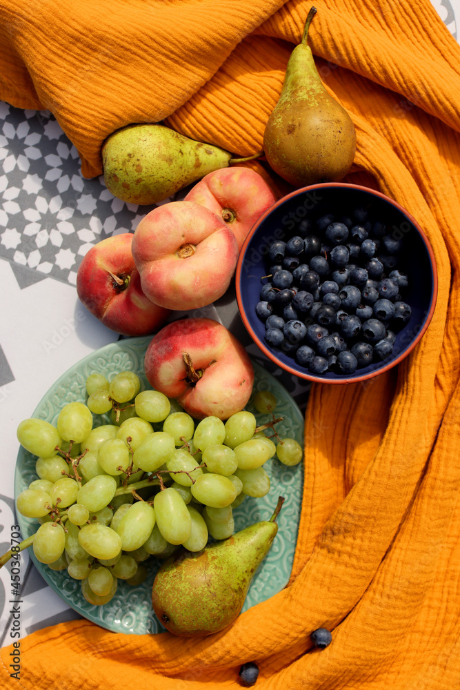 Fresh fruits and berries on a table. Top view photo of blueberry, grapes, pears and peaches. Summer food close up photo. Eating fresh concept. 