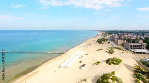 Anapa beach Jemete Black Sea in the morning, people walk along the pier along the seashore and a line of hotels