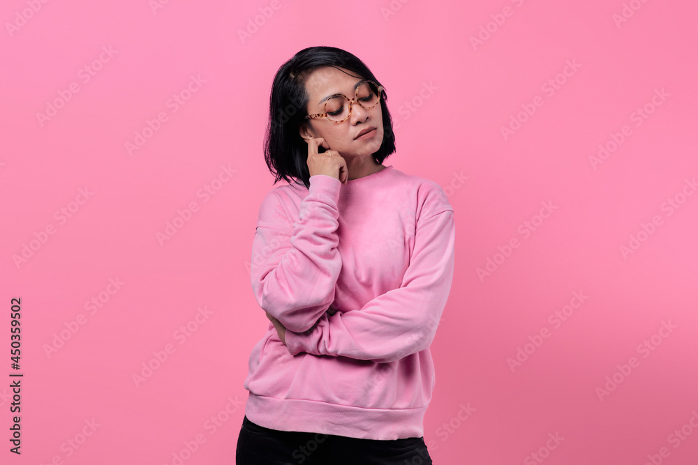 Portrait of Asian girl wearing pink jacket looking pensive, sad and unhappy Portrait of Asian girl wearing pink jacket looking pensive, sad and unhappy