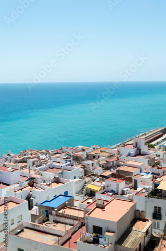 Town with traditional white houses and a pier beside the meditarranean sea in Peñiscola.