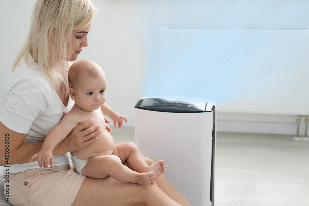 mother and baby near air purifier at home mother and baby near air purifier at home