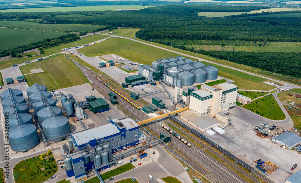 Modern granary elevator. Silver silos on agro-processing and manufacturing plant. Agricultural products, flour, cereals and grain. Aerial view panorama