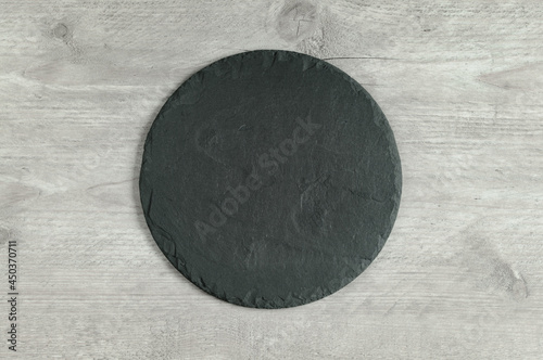 Round shaped slate serving board on gray background. Top view