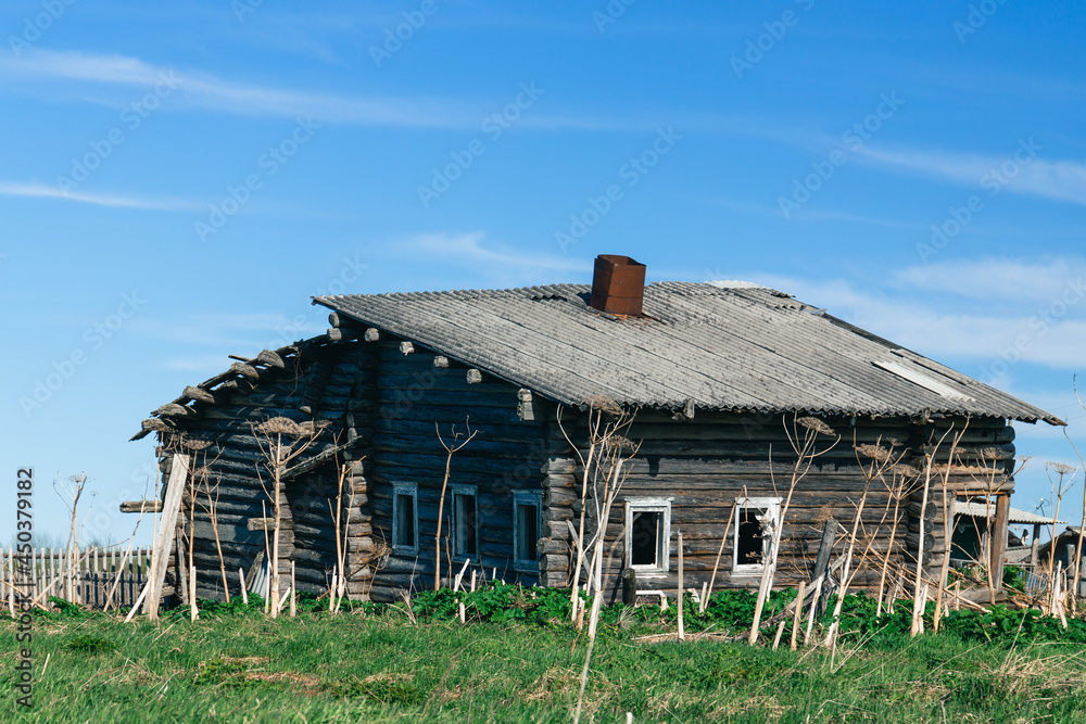 An old one-story, leaning village house made of wood is being destroyed. Russian village.