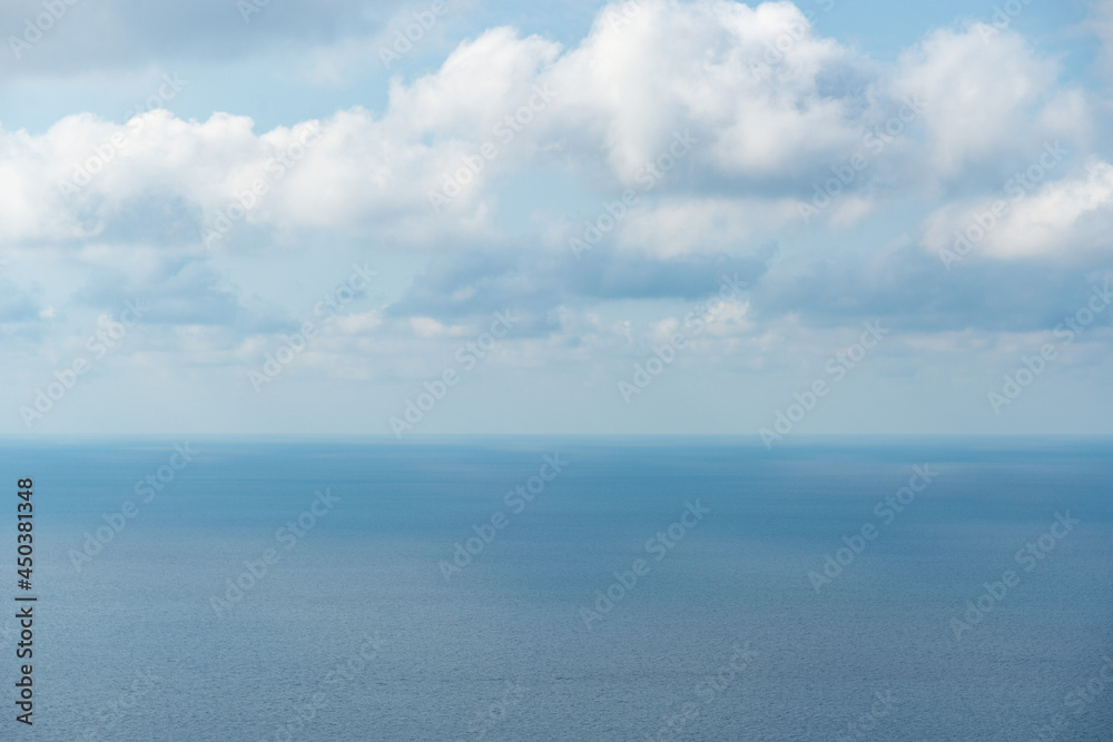 The sea and clouds, through which the sun's rays shine through, reflecting on the surface of the sea on a warm summer day. can be used as a nature background or landscape.