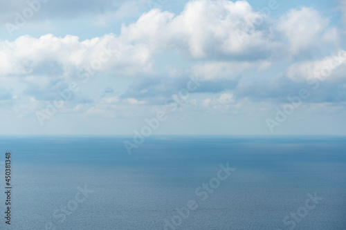 The sea and clouds, through which the sun's rays shine through, reflecting on the surface of the sea on a warm summer day. can be used as a nature background or landscape.