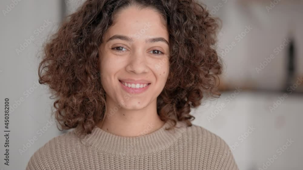 close up portrait smiling young brunette with curly hair posing looking camera joyful woman at home slow motion close up portrait smiling young brunette with curly hair posing looking camera joyful woman at home slow motion