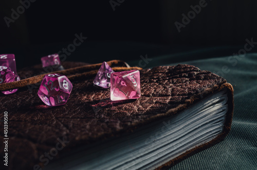 Close-up image of role-playing gaming dice on top of a leather-bound book