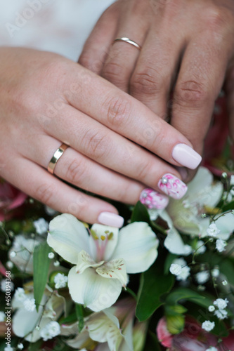 hands wedding rings bouquet