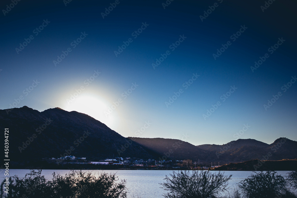 City at the foot of the hill and on the edge of the Lake in Potrero de los Funes at sunset. San Luis, Argentina (South America)