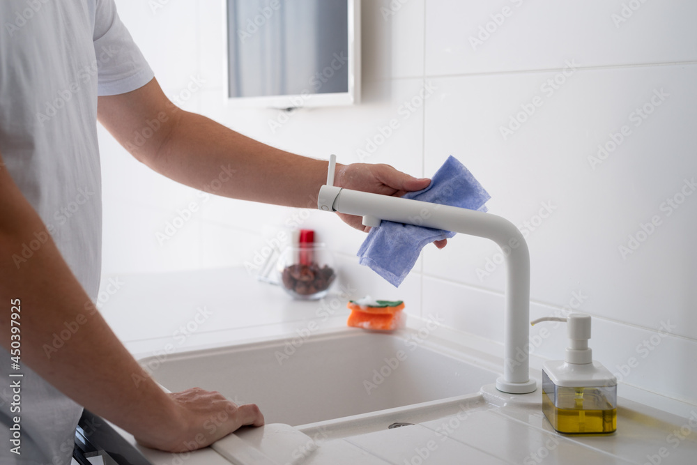 Man hand with rag cleaning the kitchen surfaces Man hand with rag cleaning the kitchen surfaces