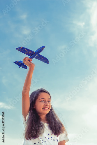 Teenager girl on a background of the sky. Girl and toy plane. Air travel