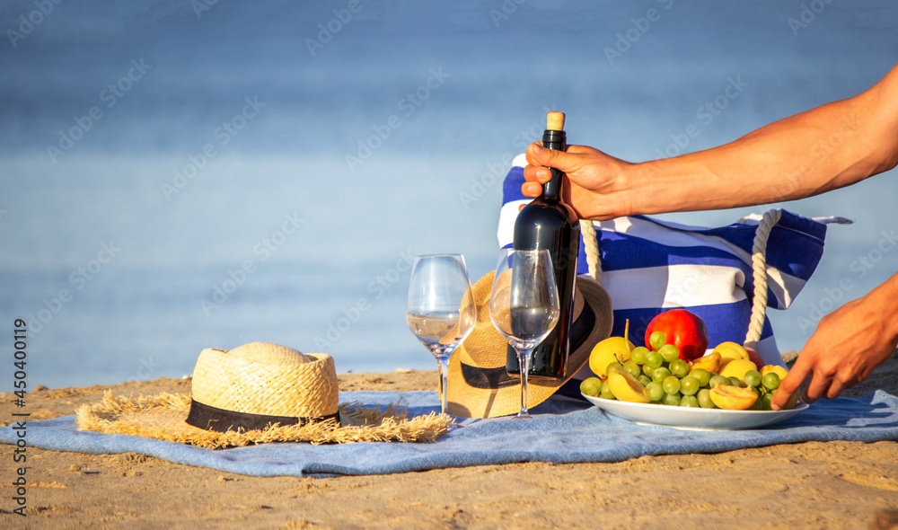 Picnic blanket, wine, fruit, beautiful sea beach. Selective focus