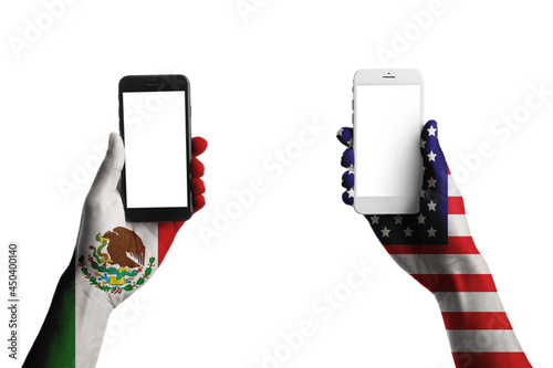 Hands painted in colors of Mexican and USA flags holding mobile phones on white background photo