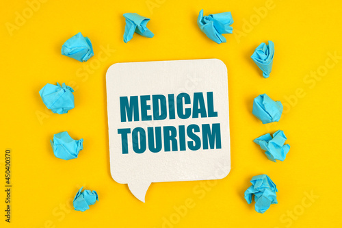On a yellow background, blue pieces of paper and a sign with the inscription - Medical Tourism © Dzmitry