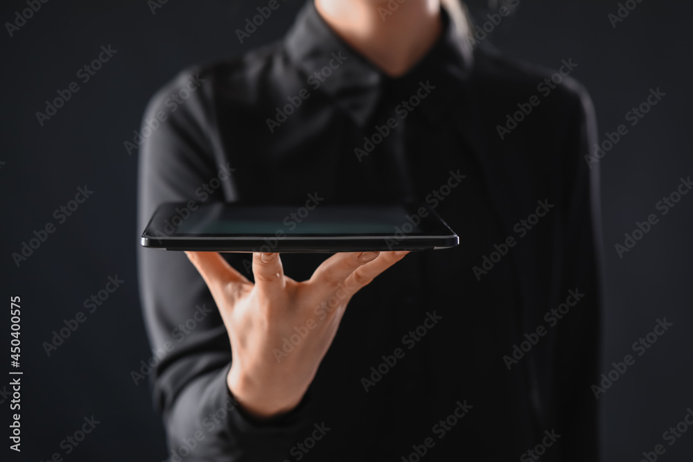 Young woman with tablet computer on dark background Young woman with tablet computer on dark background