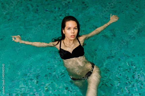 Portrait of young woman relaxing in swimming pool