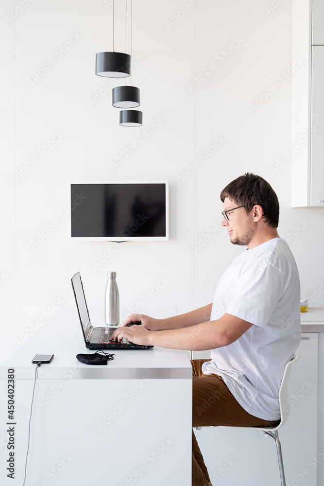 Young smiling man working with laptop from home