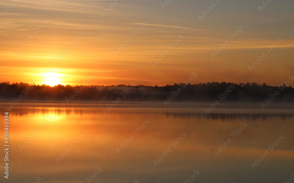 Gold Sun Rising in Sky Over Lake