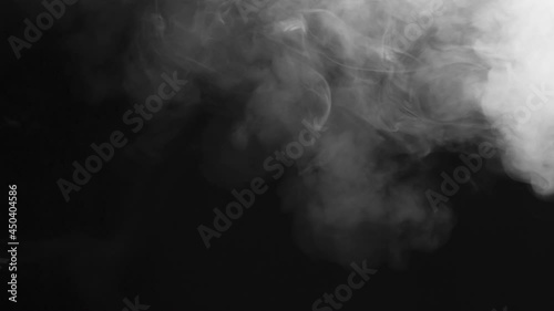 Gradual White Smoke Build-up. White smoke hangs floridly in the air and slowly spreads across the black screen photo