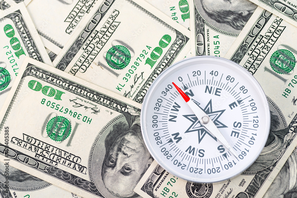Travel compass on the background of American dollars Travel compass on the background of American dollars
