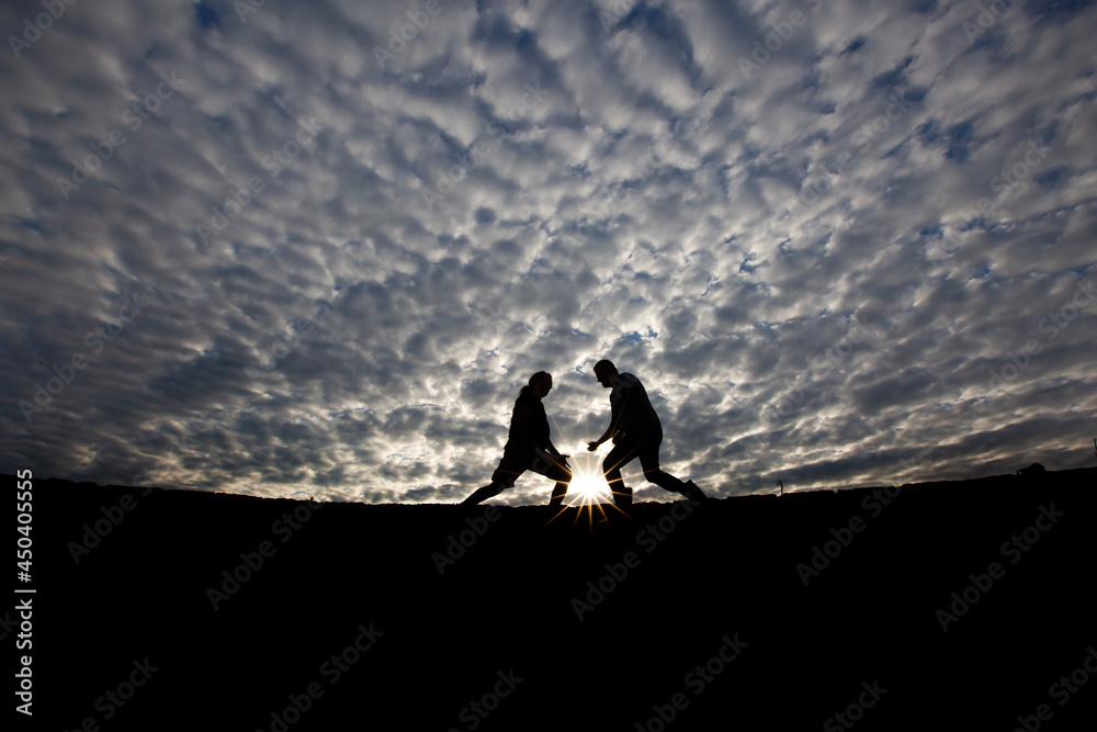 gorgeous clouds in the background and silhouette models playing games