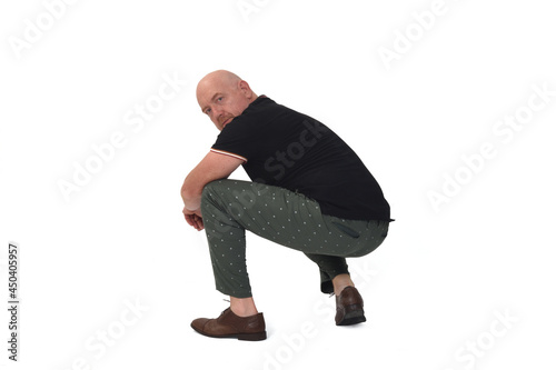 side view of a man sitting squatting on white background © curto