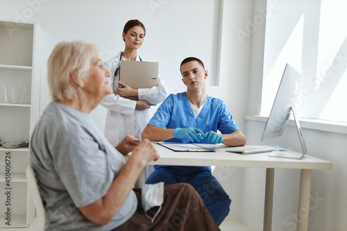 an elderly woman at a doctor s appointment and a nurse in a hospital office