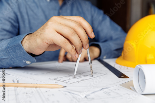 Building concept. Civil male engineer working on blueprint architectural project at desk in office