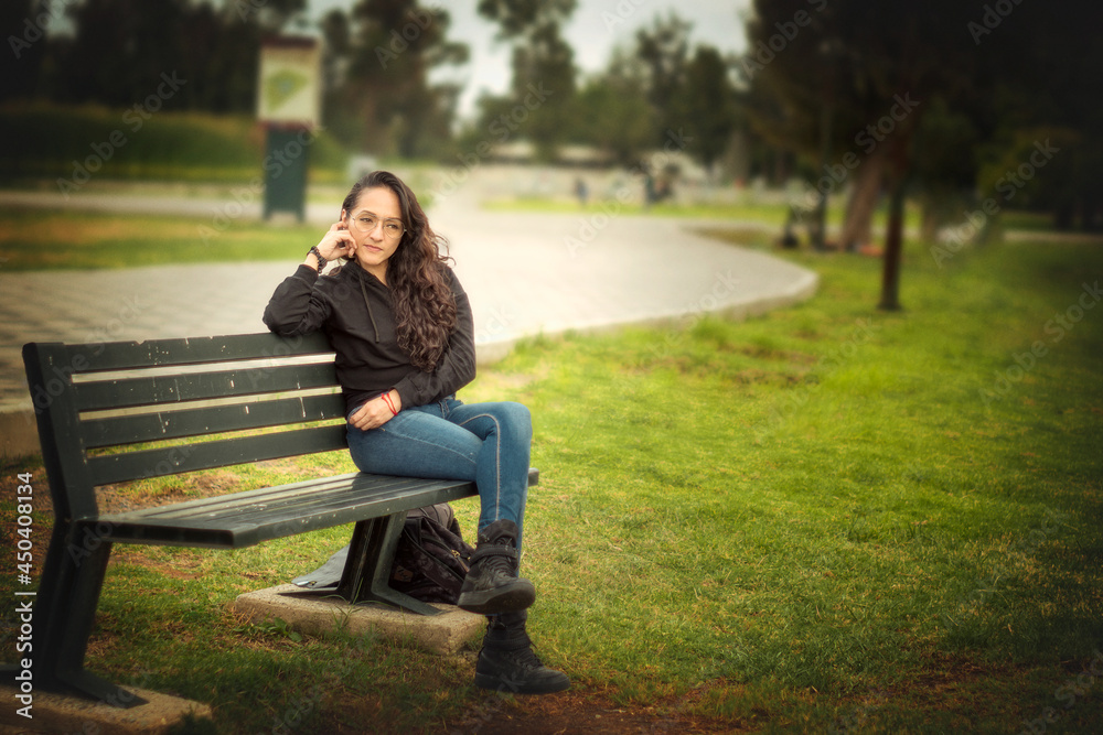 Young woman sitting on a park bench Young woman sitting on a park bench