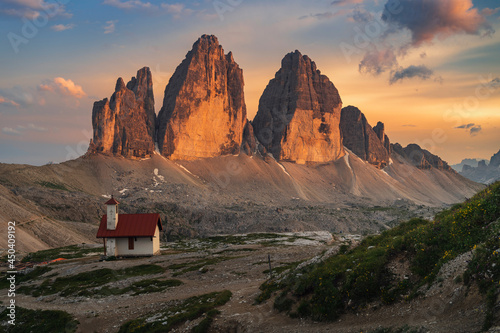 Three peaks of Tre Cime di Lavaredo during sunset with Small church in foreground