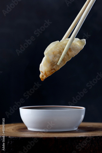 Tableau sur toile Gyoza held by asiatic chopsticks