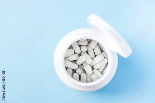 White Capsules with Medicine Drug in Whine Container Bottle