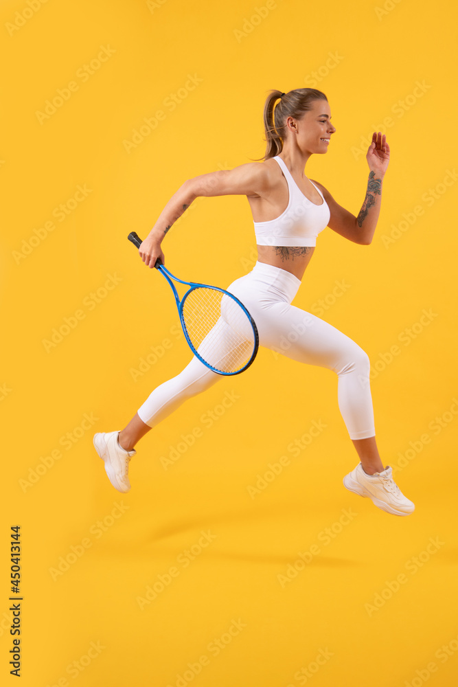 happy tennis player running with racket on yellow background, badminton