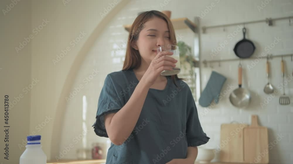 Pregnant woman concept of 4k Resolution. Asian girls are drinking milk in the kitchen. Pregnant woman concept of 4k Resolution. Asian girls are drinking milk in the kitchen.