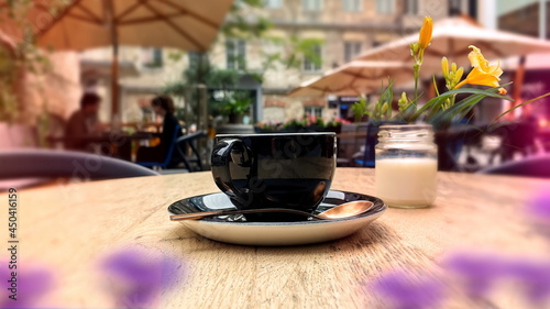 black   cup of coffee on wooden table in  street  cafe city urban life stile Rotermanni kvartal in Tallinn old town  photo