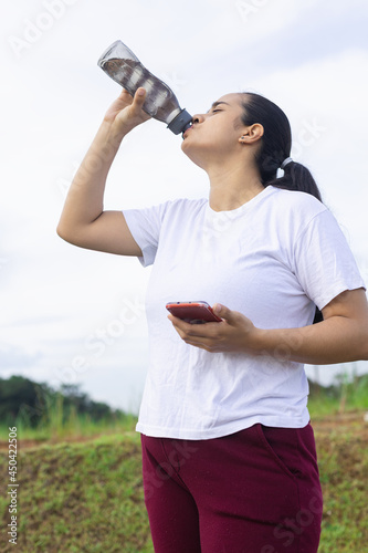 Fototapeta Naklejka Na Ścianę i Meble -  woman drinking water from her bottle