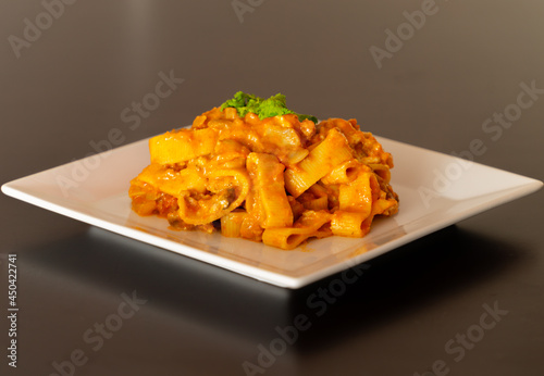 Tomato cannelloni pasta on white squared dish