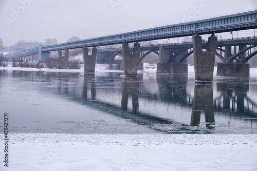 Photo  of the frozen Ob River with road and subway bridges on a winter snowy day. Novosibirsk, Russia. © Serg Zastavkin