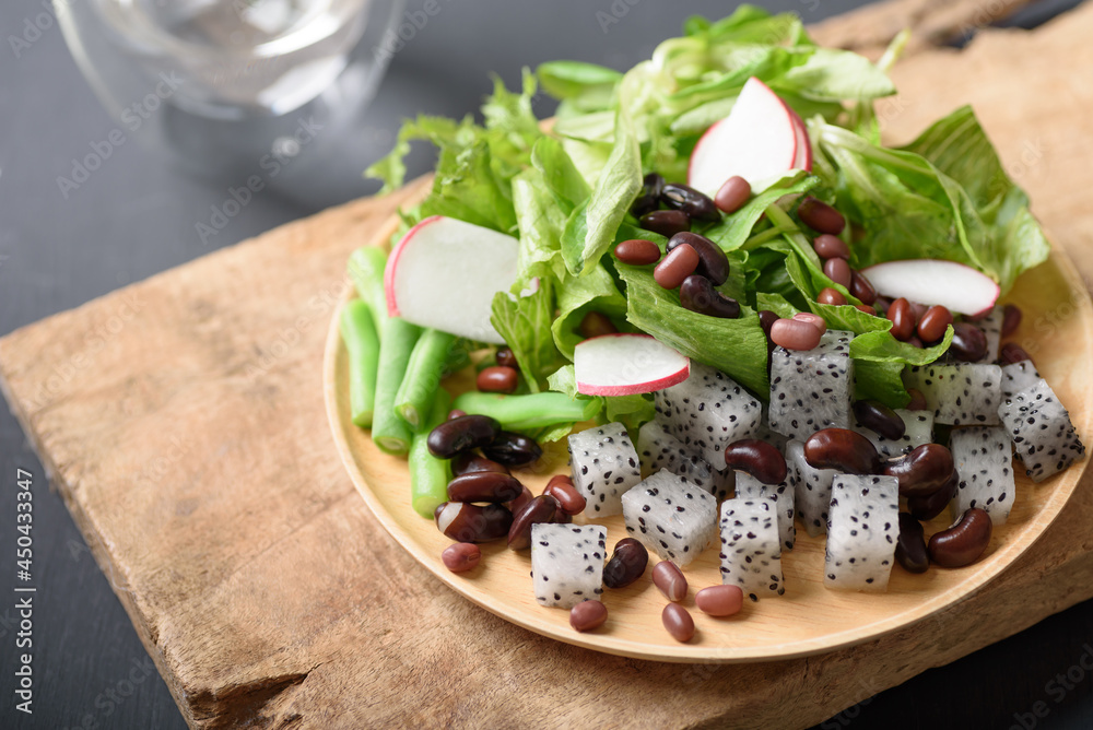 Fresh fruit and vegetable salad with kidney bean, azuki bean, green bean, dragon fruit, radish, lettuce and corn salad. Concepts of healthy food, vegetarian and lifestyle trends.