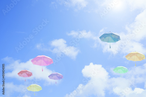 カラフルな空に浮かぶビニール傘の青空背景画像/晴れ/日差し/雨/アンブレラ